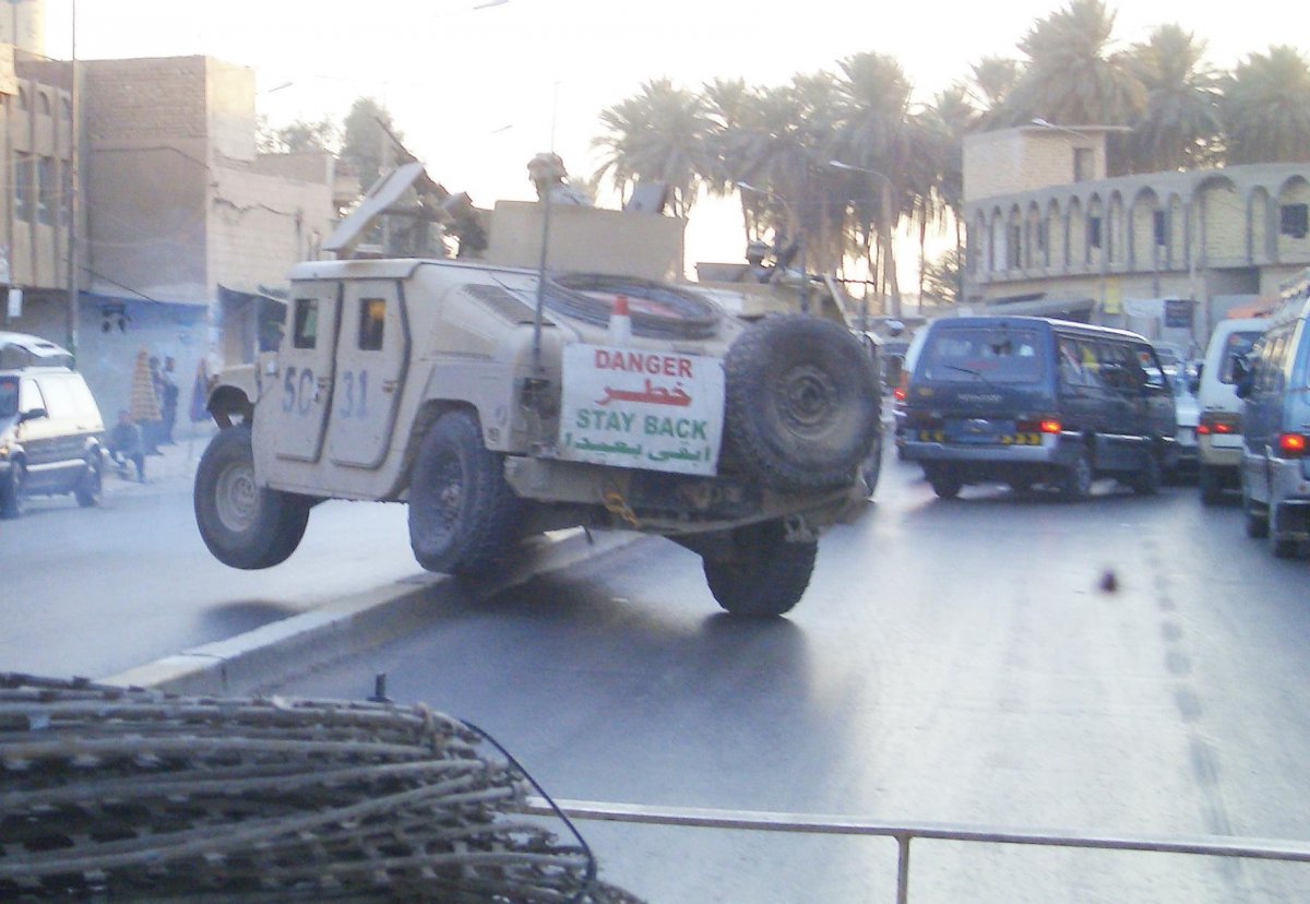 Military vehicles driving through traffic in Iraq